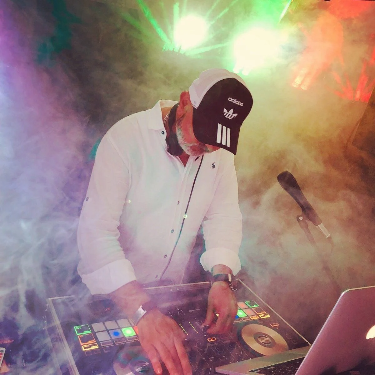 Chico konzentriert am DJ-Pult im Licht der Veranstaltung