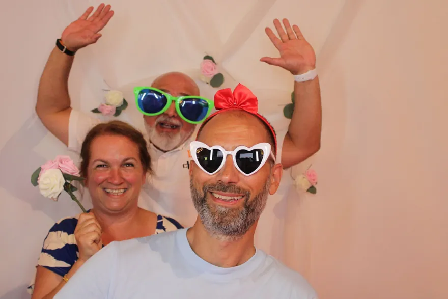 Chico und Gäste mit bunten Partybrillen vor einer Fotowand