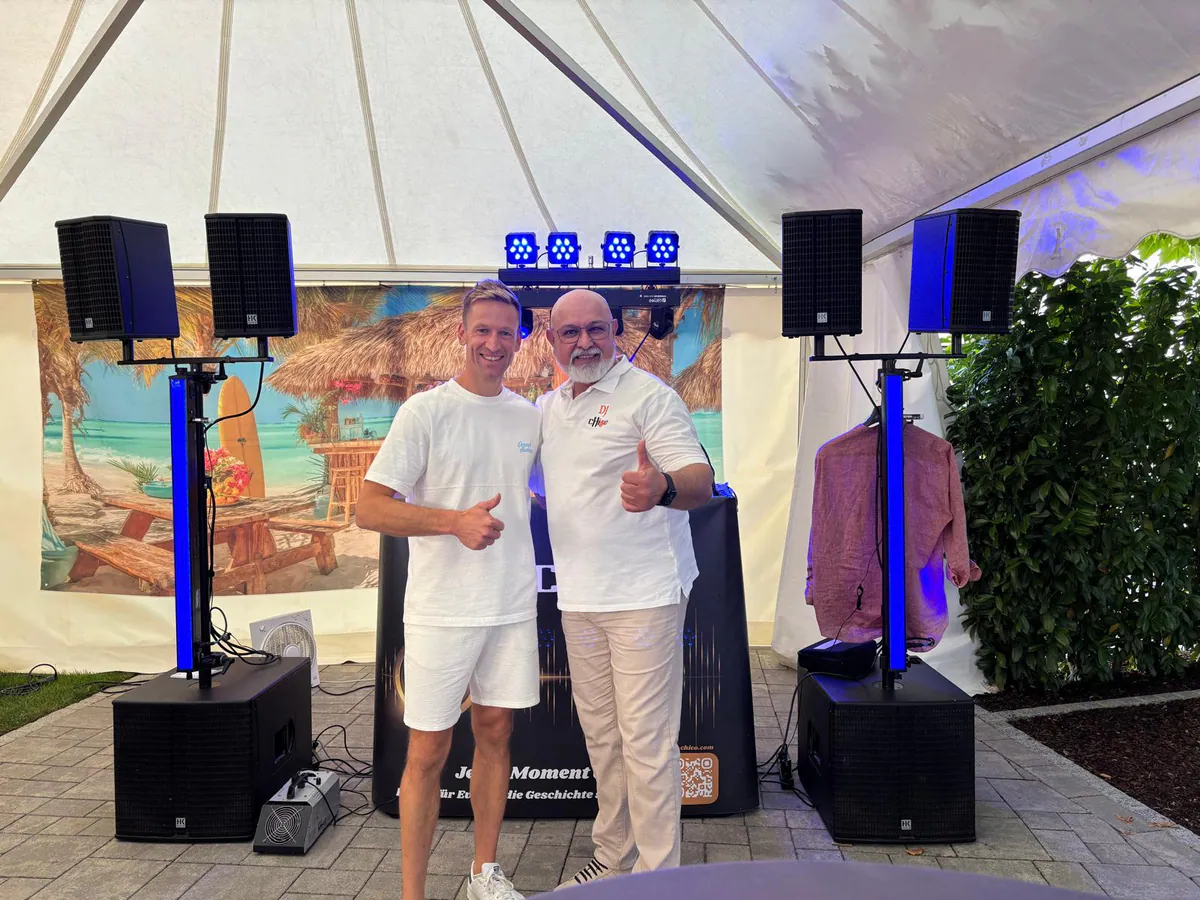 DJ CHiCO mit einem Kunden vor seiner Ton- und Lichttechnik